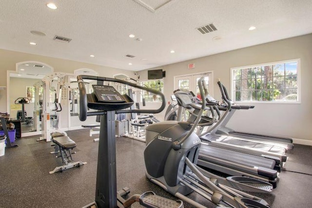 exercise room featuring french doors and a textured ceiling