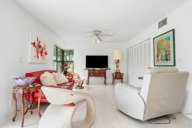 tiled living room featuring a textured ceiling and ceiling fan