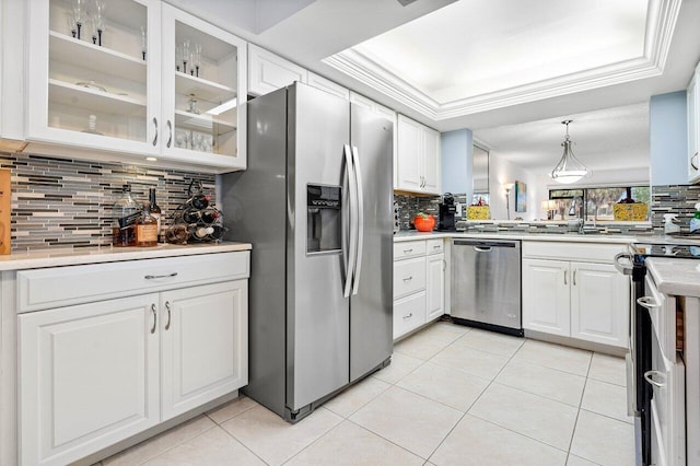 kitchen with decorative light fixtures, white cabinets, decorative backsplash, and appliances with stainless steel finishes