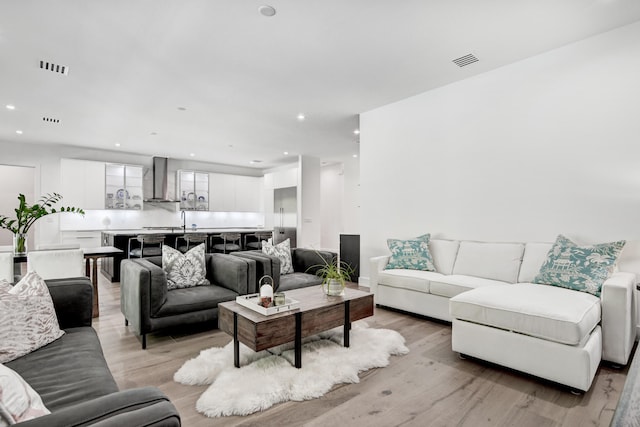 living room with light hardwood / wood-style floors and sink