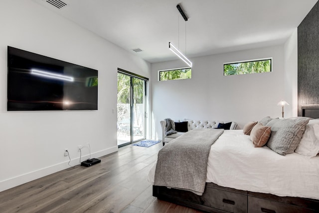 bedroom featuring wood-type flooring and access to outside