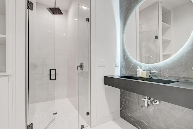 bathroom with a shower with door and tasteful backsplash