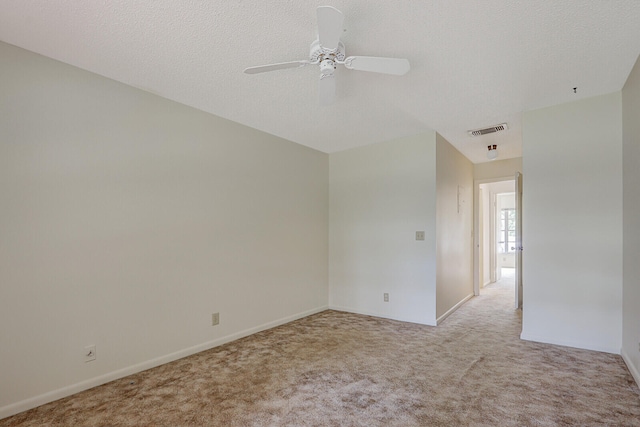 carpeted spare room featuring a textured ceiling and ceiling fan