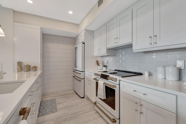 kitchen featuring white cabinetry, electric range, and sink