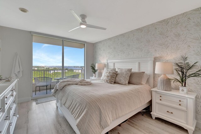 bedroom featuring ceiling fan, light wood-type flooring, and wooden walls