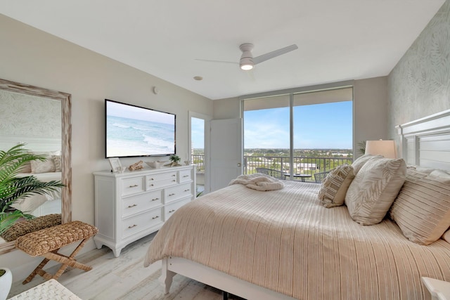 bedroom featuring light hardwood / wood-style floors, ceiling fan, access to outside, and floor to ceiling windows