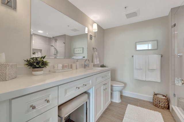 bathroom with toilet, vanity, and walk in shower