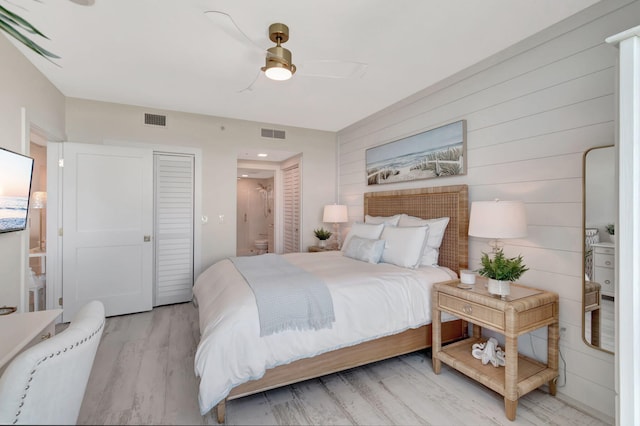 bedroom featuring connected bathroom, ceiling fan, and light hardwood / wood-style flooring