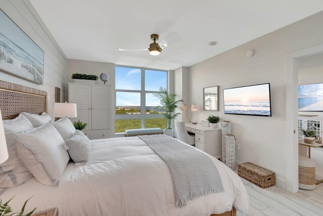 bedroom with access to outside, expansive windows, ceiling fan, and light hardwood / wood-style floors