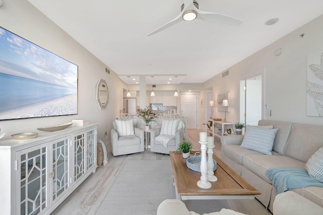 living room with ceiling fan and light hardwood / wood-style flooring