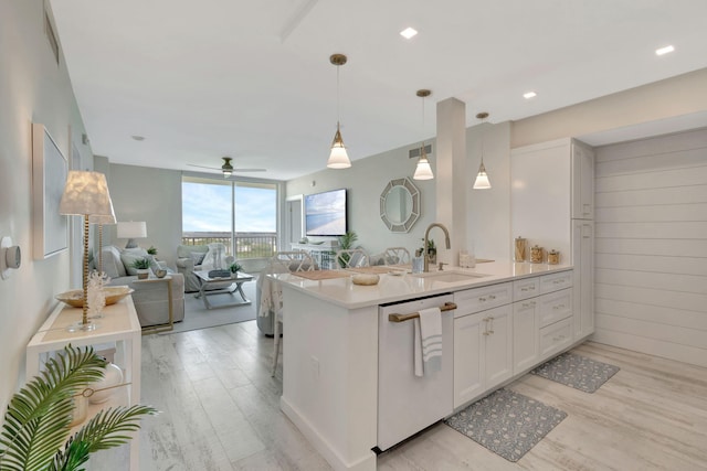 kitchen with floor to ceiling windows, light wood-type flooring, white dishwasher, hanging light fixtures, and white cabinets