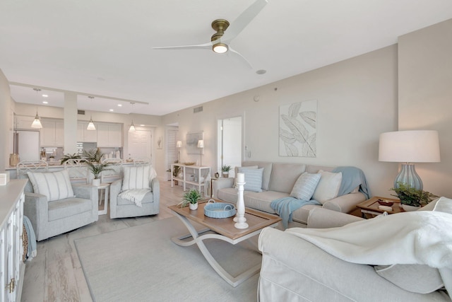 living room with ceiling fan and light hardwood / wood-style flooring