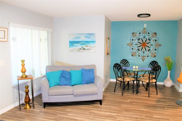 living area with baseboards and wood finished floors