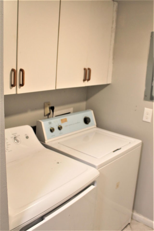 laundry room featuring separate washer and dryer and cabinets