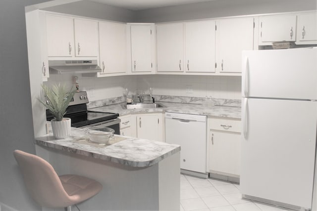 kitchen featuring white appliances, a peninsula, light countertops, under cabinet range hood, and a sink