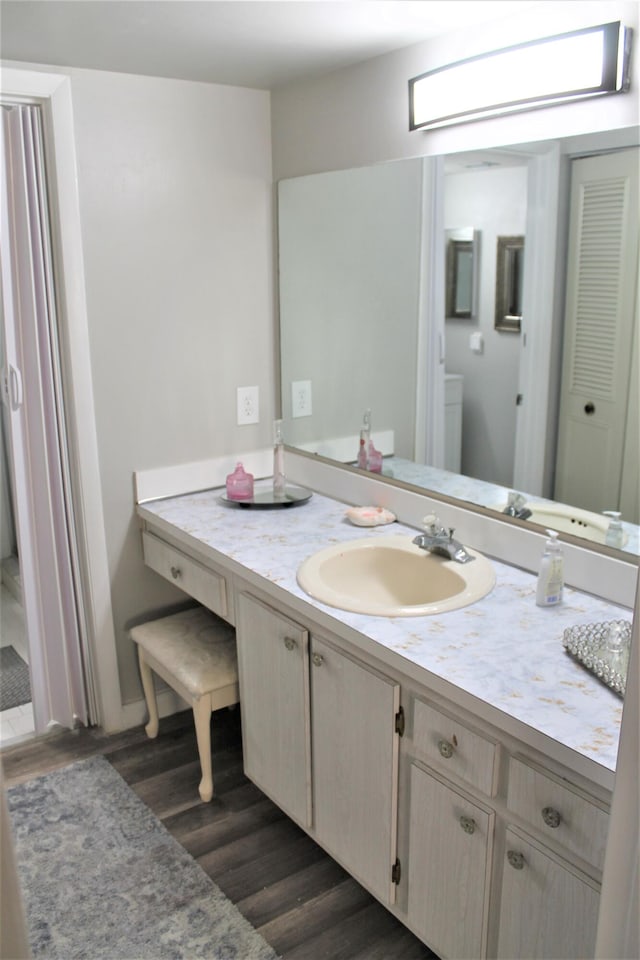 bathroom with vanity, toilet, and hardwood / wood-style floors