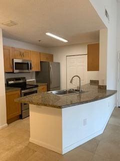 kitchen with a breakfast bar, stainless steel appliances, sink, and kitchen peninsula