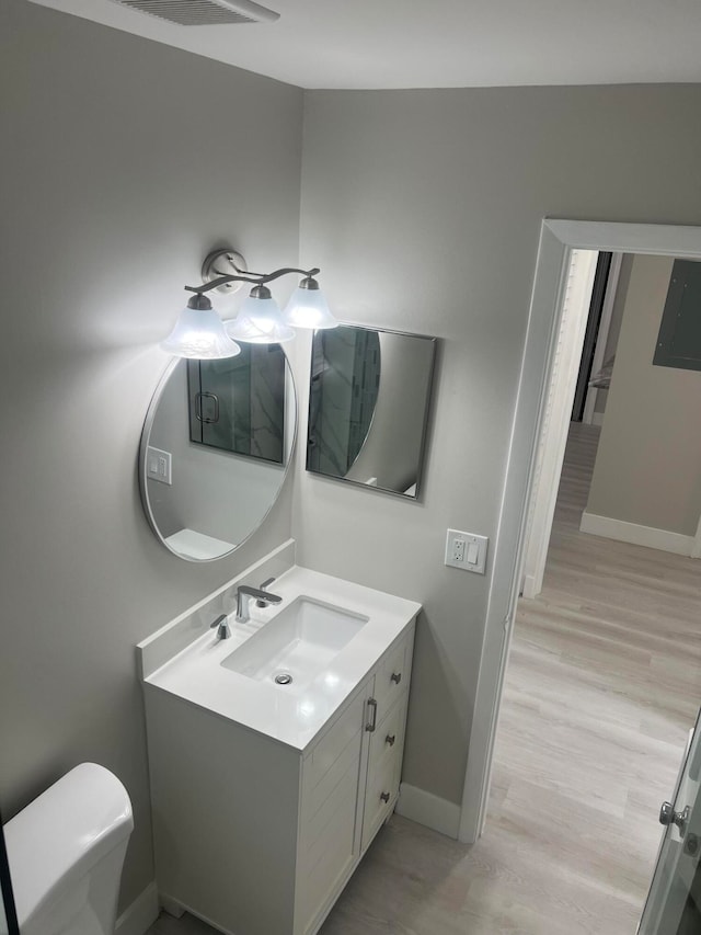 bathroom featuring vanity, toilet, and wood-type flooring