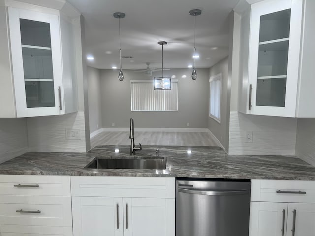 kitchen featuring hanging light fixtures, sink, stainless steel dishwasher, white cabinetry, and tasteful backsplash