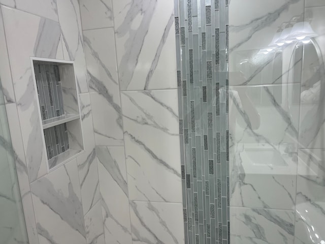 interior details featuring a tile shower