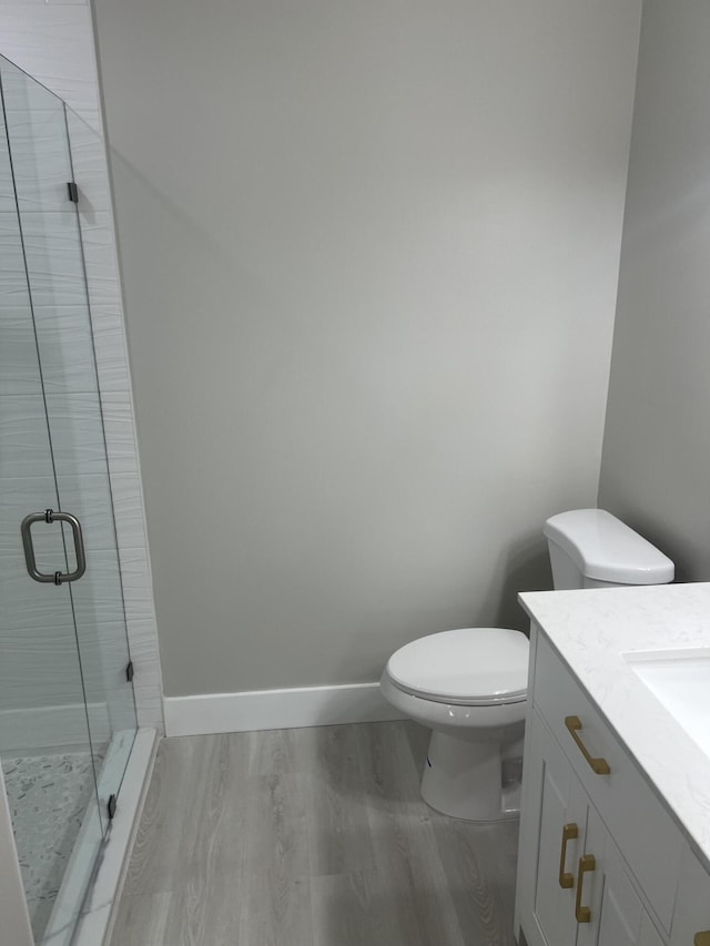 14910 Wildflower Ln, Delray Beach, FL 33446 - bathroom with a stall shower, vanity, toilet, wood finished floors, and baseboards