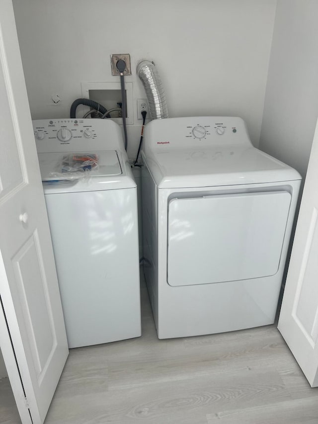 laundry room featuring independent washer and dryer and light wood-type flooring