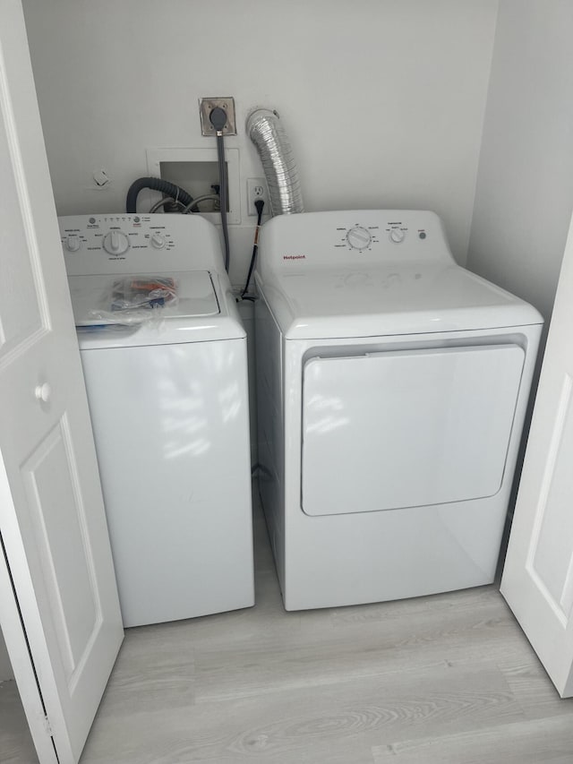 14910 Wildflower Ln, Delray Beach, FL 33446 - washroom with washing machine and dryer and light wood finished floors