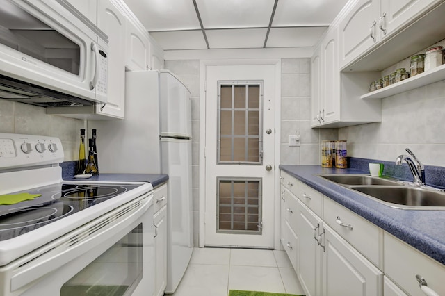 kitchen featuring sink, white appliances, white cabinetry, and light tile patterned floors