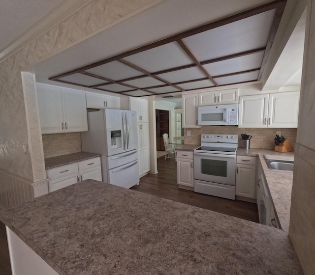 kitchen featuring white appliances, dark hardwood / wood-style floors, white cabinetry, and backsplash