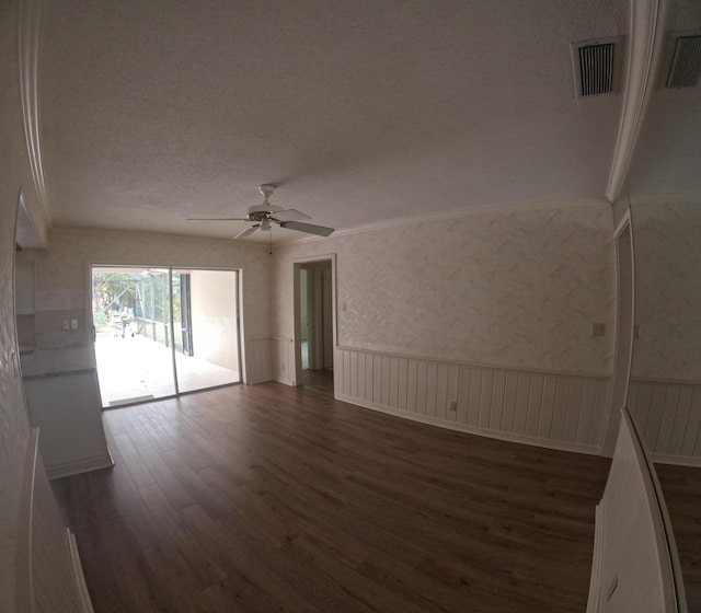 spare room with a textured ceiling, ceiling fan, and dark wood-type flooring