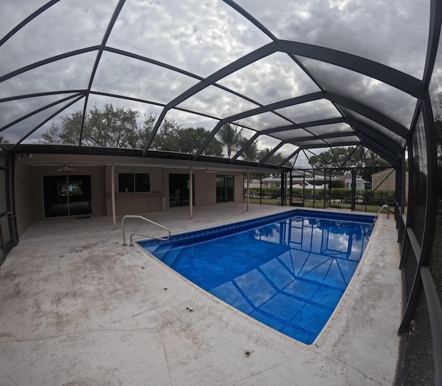 view of swimming pool featuring a patio area, ceiling fan, and a lanai