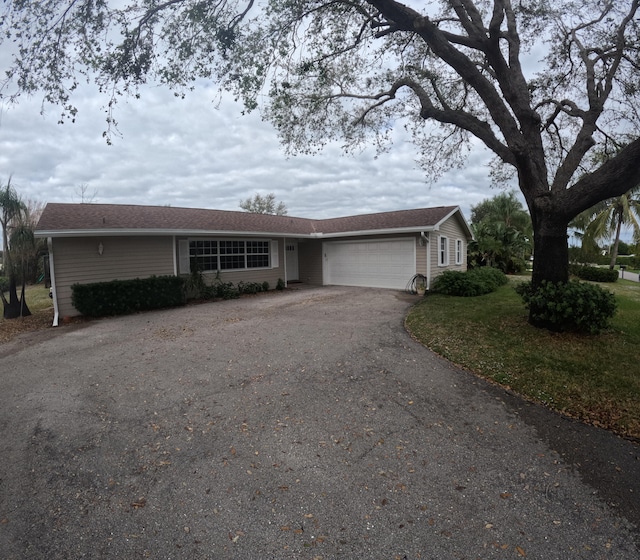 ranch-style house with a front yard and a garage