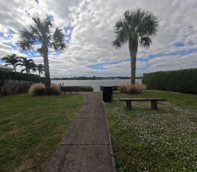 view of home's community with a water view and a lawn