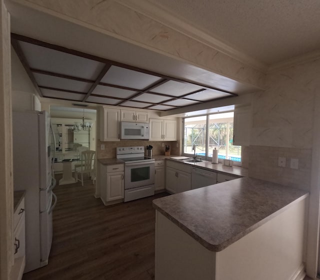 kitchen featuring kitchen peninsula, white appliances, sink, white cabinets, and dark hardwood / wood-style floors