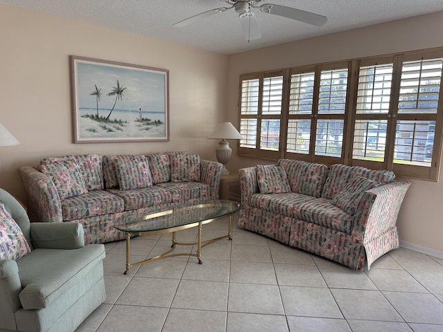 living room with light tile patterned flooring, ceiling fan, and a textured ceiling