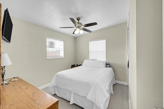 bedroom featuring ceiling fan, a textured ceiling, carpet, and multiple windows