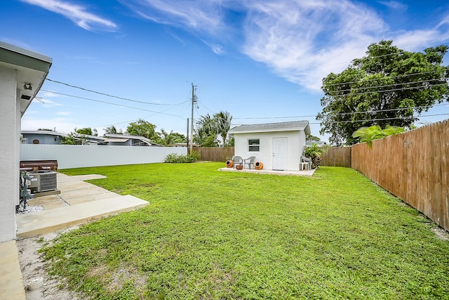 view of yard with central air condition unit, a patio area, and a storage unit