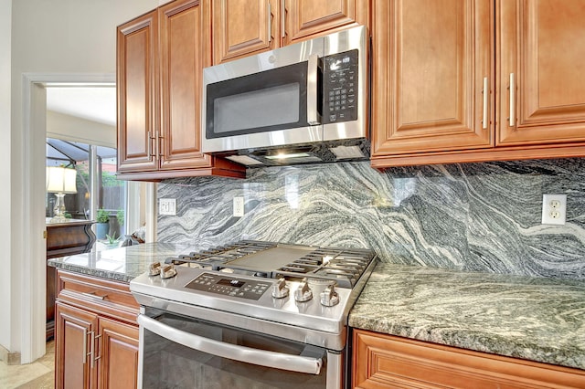 kitchen featuring stone counters, stainless steel appliances, and backsplash