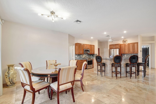 dining room featuring a textured ceiling and ceiling fan with notable chandelier