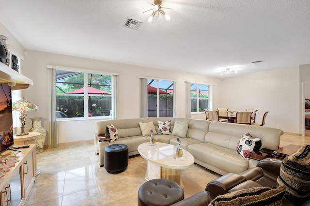 living room with a textured ceiling and light tile patterned flooring