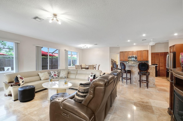 tiled living room featuring a textured ceiling