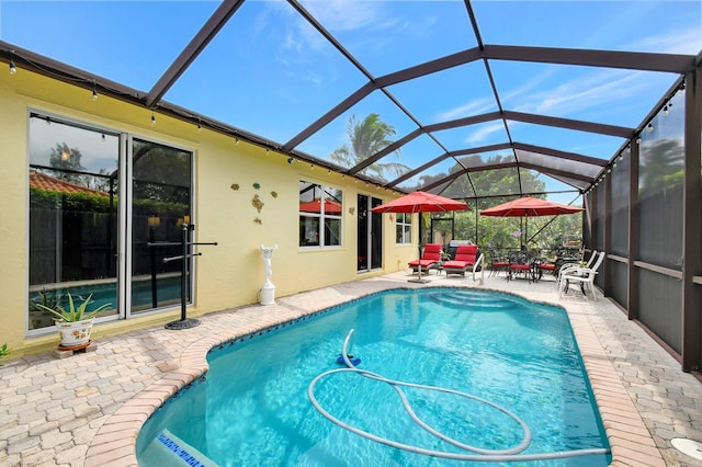 view of pool with a patio and a lanai