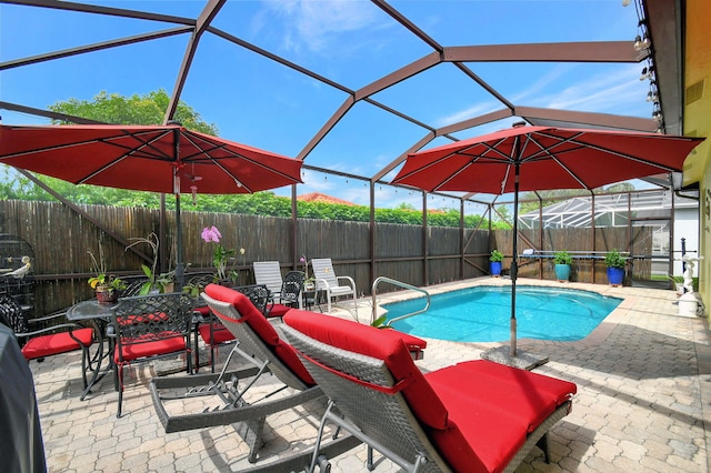 view of swimming pool featuring a patio area and a lanai