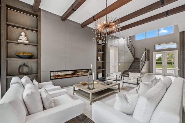 living room with french doors, beam ceiling, a towering ceiling, and an inviting chandelier