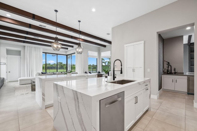 kitchen featuring dishwasher, beam ceiling, a center island with sink, sink, and pendant lighting