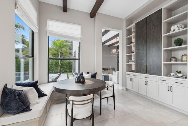 tiled dining room featuring beamed ceiling and a chandelier