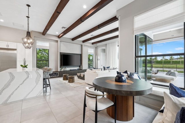 tiled dining room with beam ceiling and a wealth of natural light