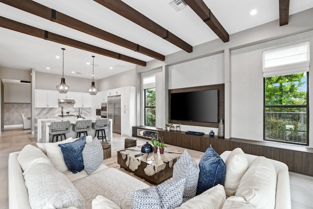 living room featuring beam ceiling and light tile patterned floors