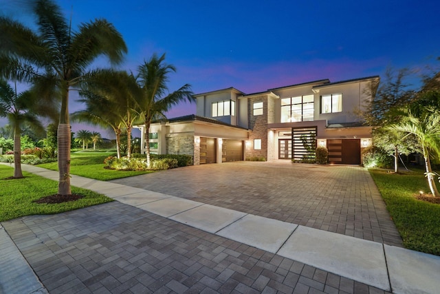 contemporary home featuring a yard and a garage