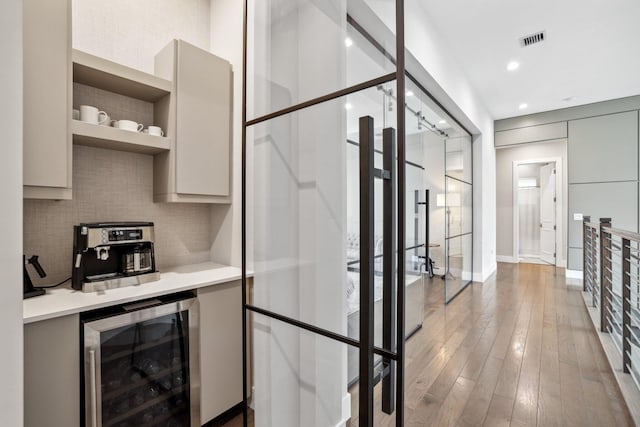 kitchen with wine cooler, tasteful backsplash, and wood-type flooring